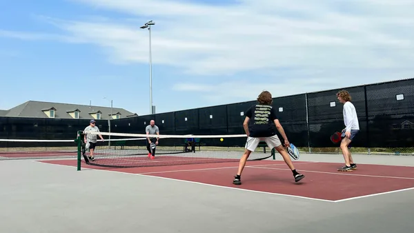 Pickleball game in progress with paddles and balls